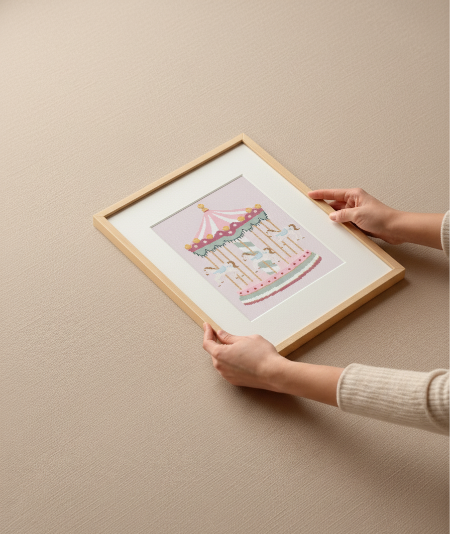 Framed artwork with a colorful design held by a person against a beige wall