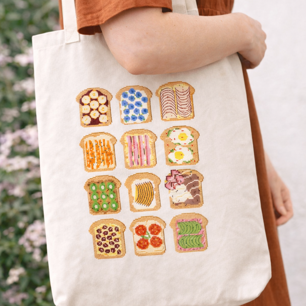 Toast cross-stitch pattern with 12 slices of toast and different colorful toppings, embroidered on a tote bag