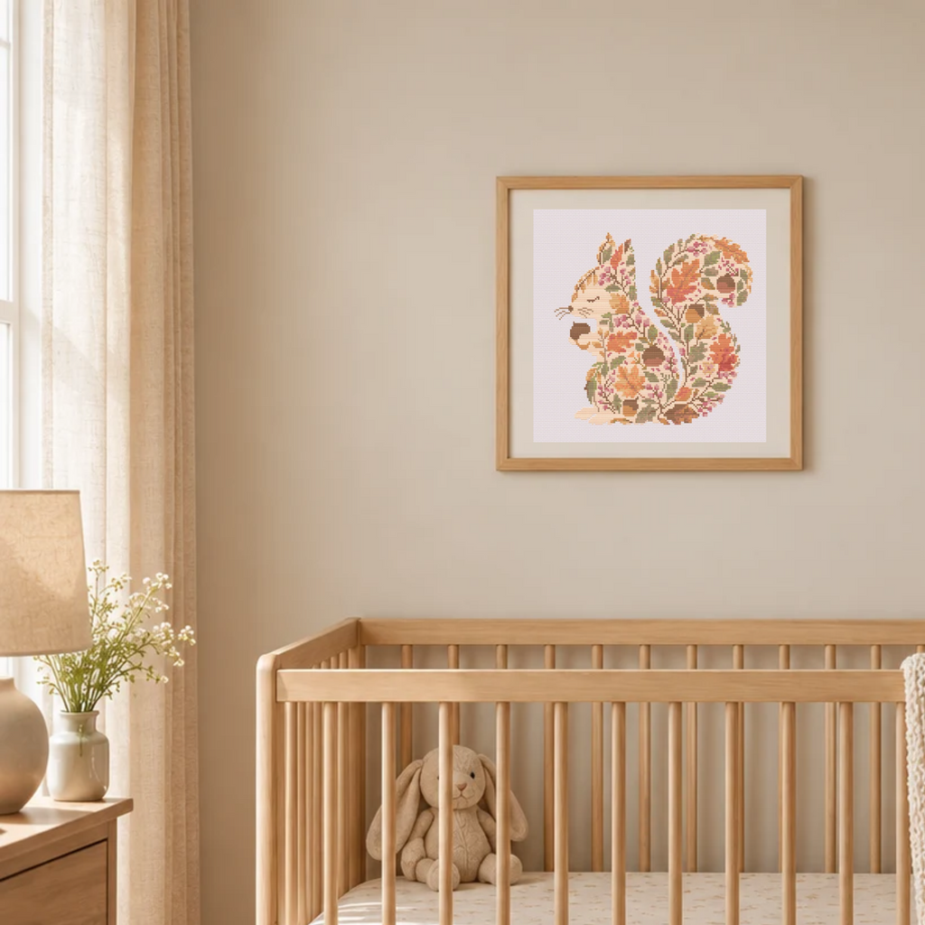 A framed art print of a squirrel made of autumn leaves hanging on a beige wall above a wooden baby crib with a stuffed bunny inside.