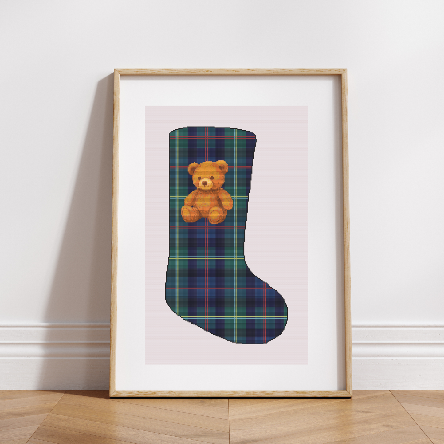 Christmas stocking cross stitch pattern with plaid background and traditional teddy bear.